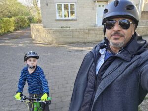 A man and a boy in cycle helmets pause for a selfie